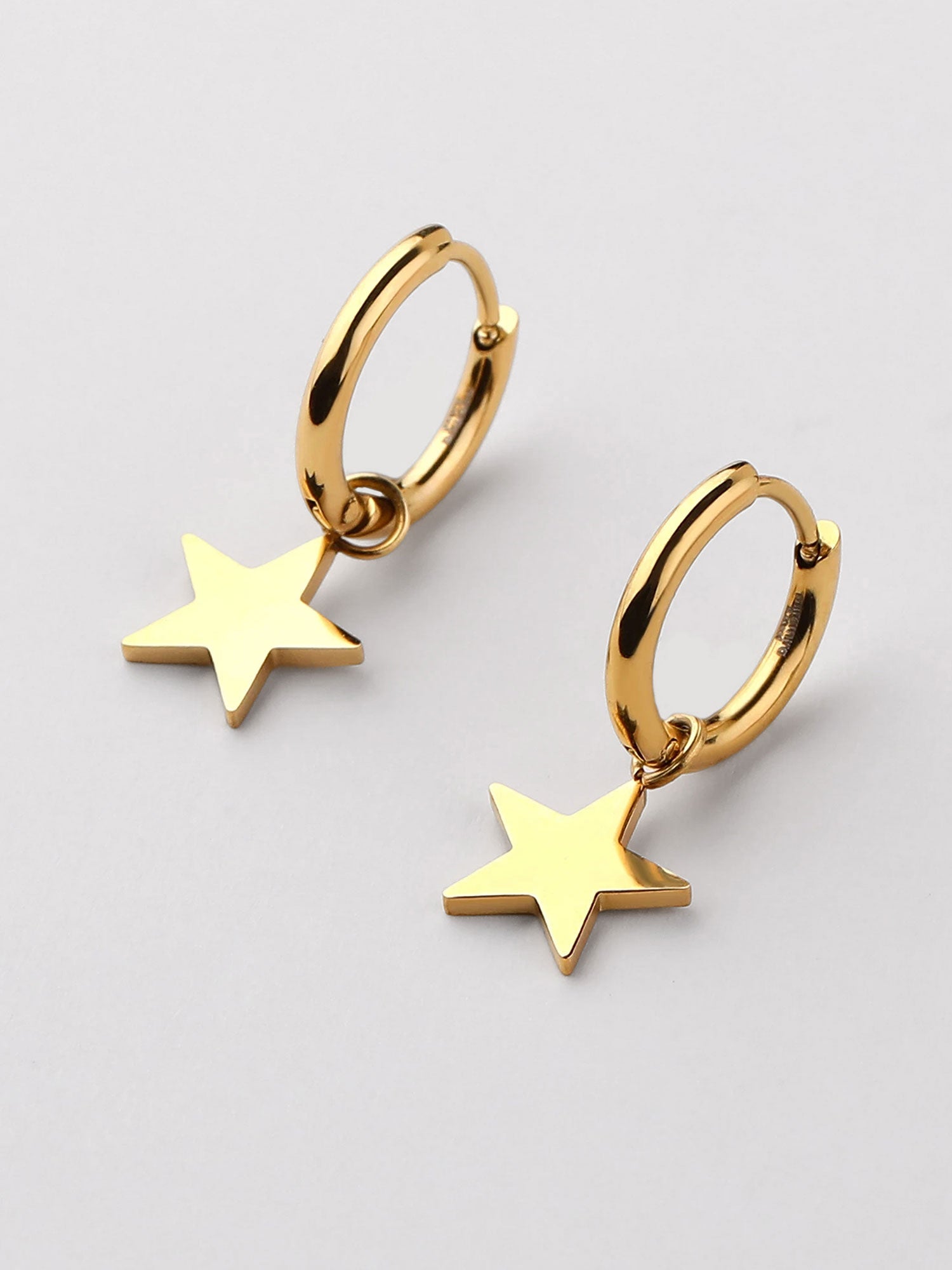 Brincos dourados com pendente estrela